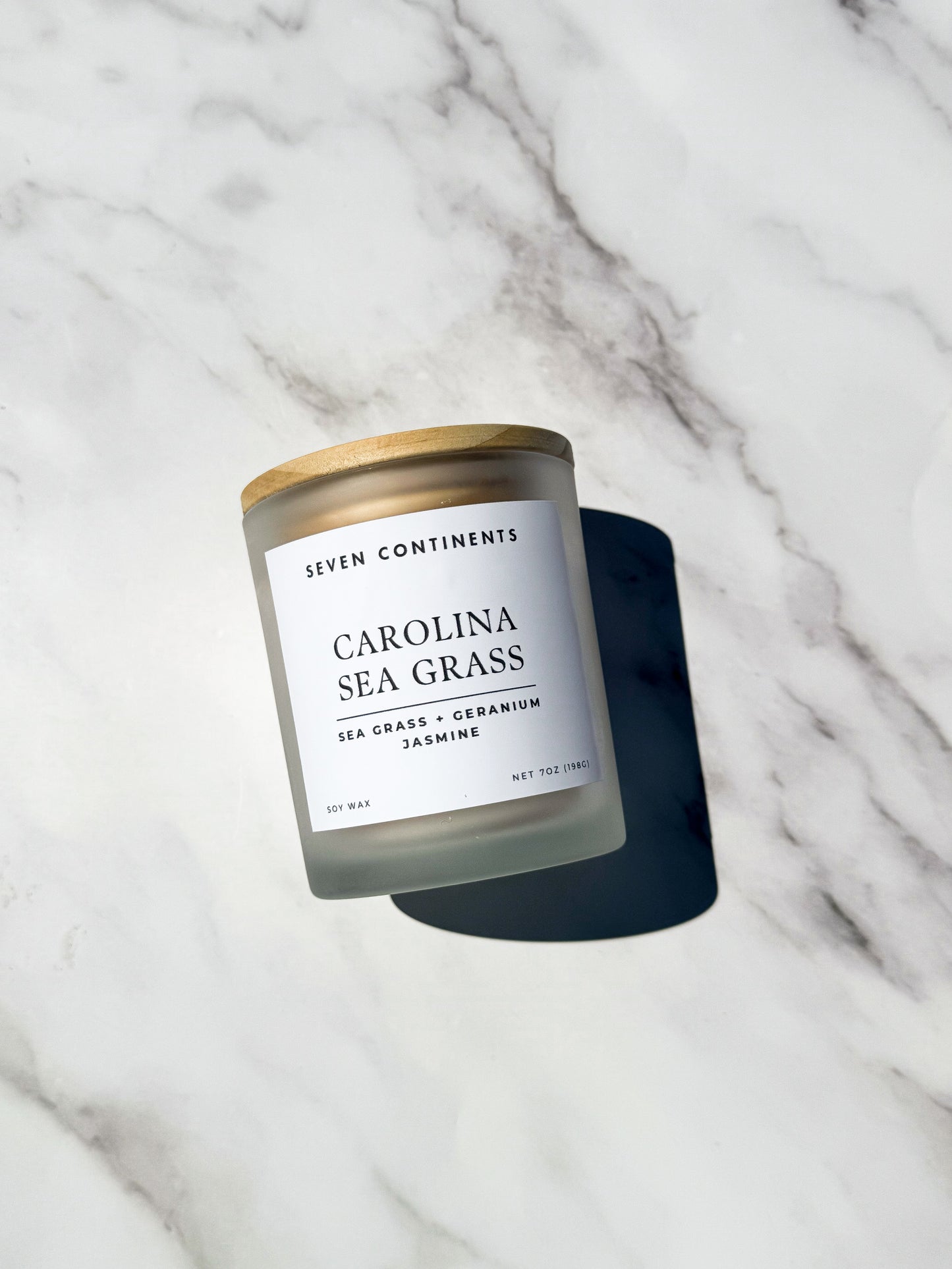 Close-up of Carolina Sea Grass candle label with sea grass, geranium, and jasmine scent notes