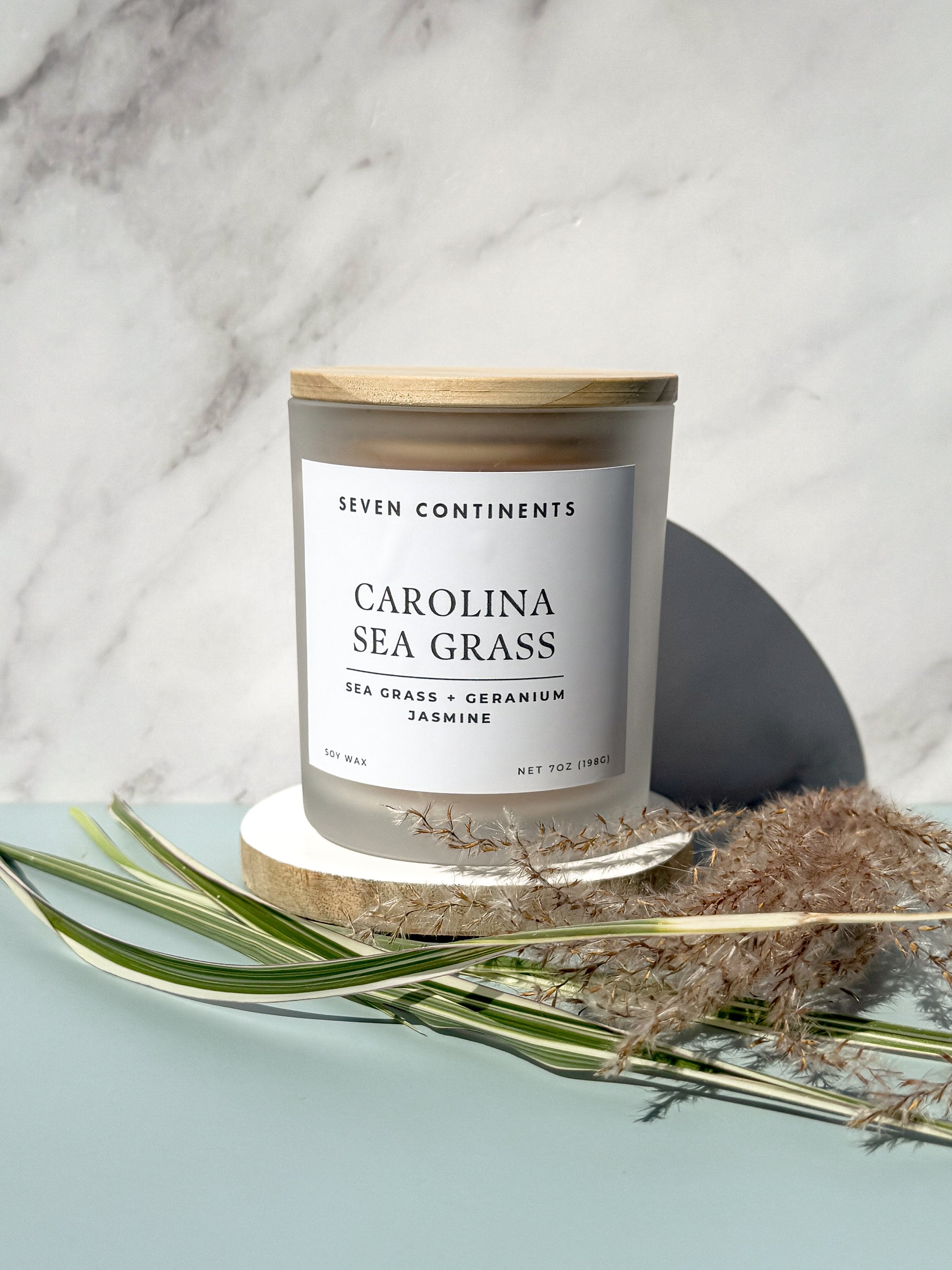 Close-up of Carolina Sea Grass candle label with sea grass, geranium, and jasmine scent notes