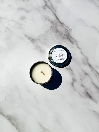 Candle with lid labeled 'Sedona Sunset' on a marble surface